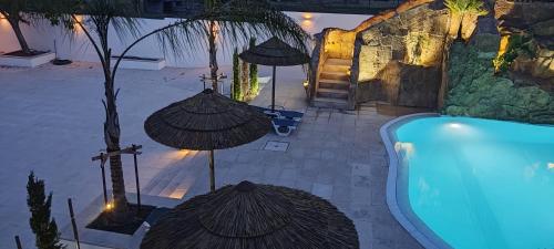 a resort with a swimming pool with umbrellas at Casa Almeida in Vimieiro