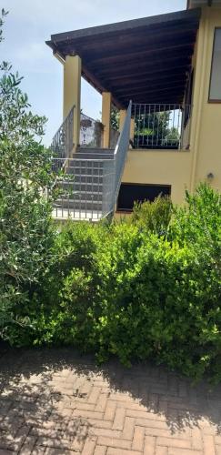 a building with stairs and bushes in front of it at Villa Sorrentina in Alghero