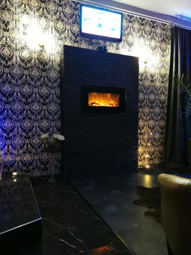 a living room with a fireplace with a tv at Wellness Stodolni Ostrava in Ostrava