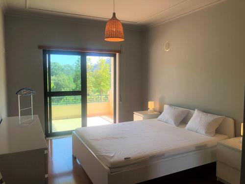 ein Schlafzimmer mit einem Bett und einem großen Fenster in der Unterkunft Faraway Lake in Ferreira do Zêzere