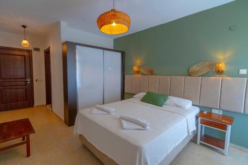 a bedroom with a large white bed in a room at Xanthos Boutique Hotel Patara in Patara