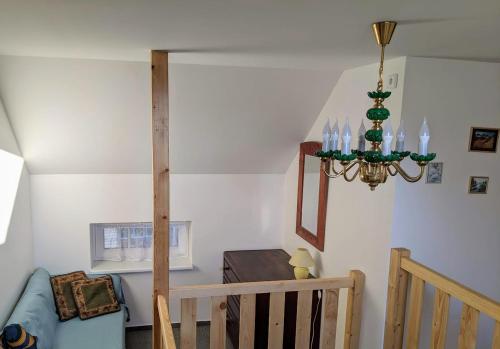 a staircase with a chandelier in a living room at Chalupa u rybníka Střehom in Dolní Bousov