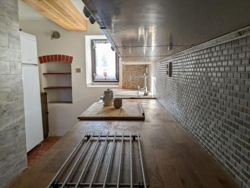 a kitchen with a sink and a brick wall at Chalupa u rybníka Střehom in Dolní Bousov