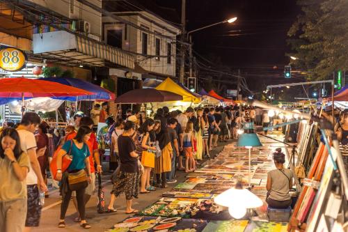 a crowd of people walking around a market at night at Parasol Inn Chiang Mai Old City in Chiang Mai