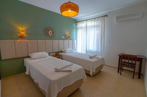 a hotel room with two beds and a window at Xanthos Boutique Hotel Patara in Patara