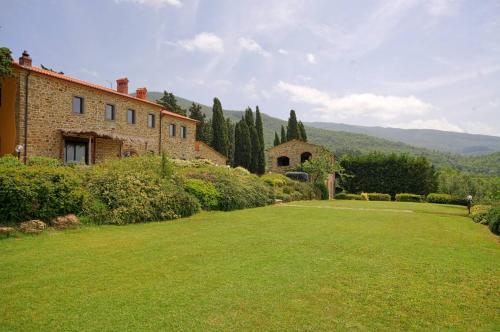 a large yard with a building and a house at Villa Poggio dei Cipressi in Subbiano