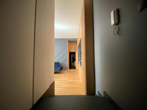 a hallway leading to a living room with a blue couch at Apartamenty Osmolice w Stawach in Dęblin