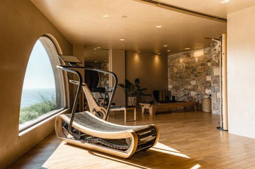 a chair in a room with a large window at Acro Suites - A Wellbeing Resort in Agia Pelagia