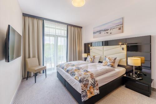 pokój hotelowy z dużym łóżkiem i oknem w obiekcie Apartament z aneksem kuchennym i basenem 426 Diune Hotel Resort w Kołobrzegu