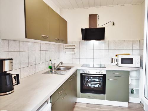 a kitchen with a sink and a microwave at Bungalow Krzyzaniak in Lohsa