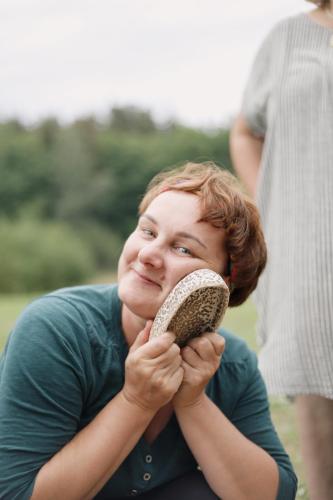 a woman is smiling while holding a shoe at Amatų kalnelis in Anykščiai