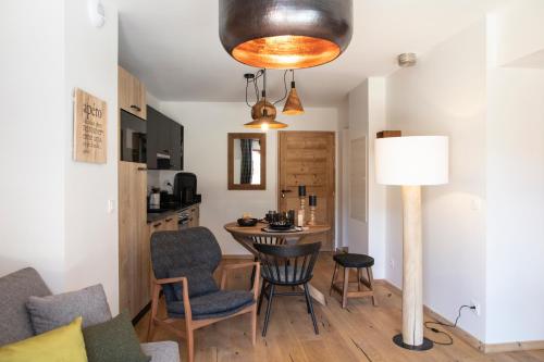 salon ze stołem, krzesłami i lampką w obiekcie TERRESENS - L'ETENDARD w mieście Vaujany