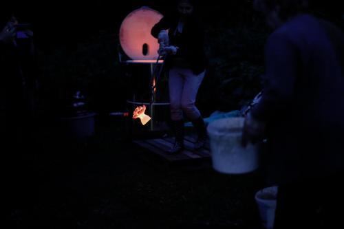 a person is lighting a lantern in the dark at Amatų kalnelis in Anykščiai