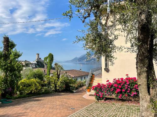 een uitzicht op het water vanuit een huis met bloemen bij Appartamenti Villa Eden in Malcesine