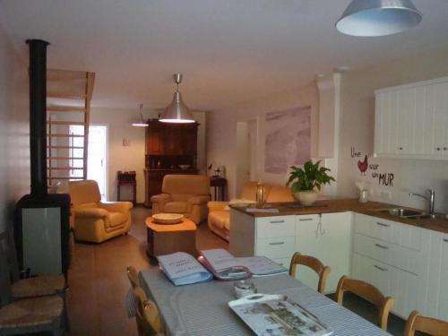 une cuisine et un salon avec une table et des chaises dans l'établissement Grande ferme rénovée avec équipements familiaux, proche de Bergues et Dunkerque - FR-1-510-169, à Quaëdypre