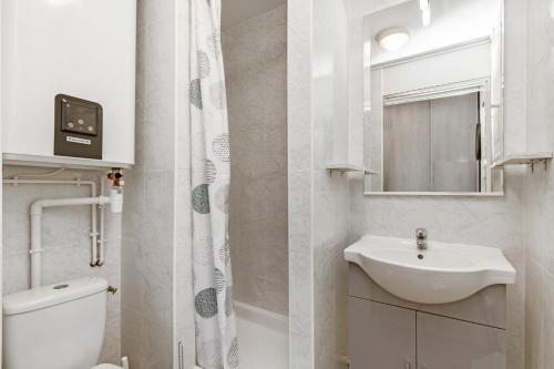 een witte badkamer met een wastafel en een toilet bij Studio Vue mer panoramique, piscine Port Vénus village naturiste in Cap d'Agde