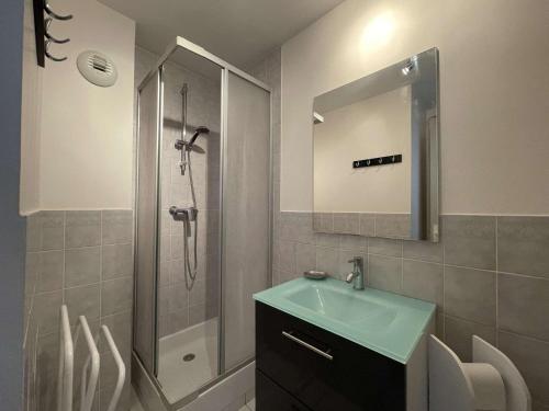 y baño con lavabo y ducha con espejo. en Appartement La Rochelle, 1 pièce, 2 personnes - FR-1-246-607 en La Rochelle