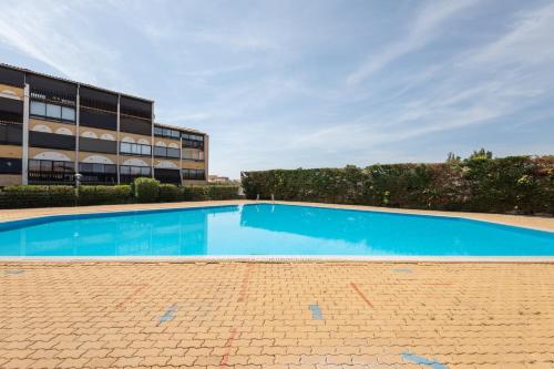 une piscine vide en face d'un bâtiment dans l'établissement Studio Vue mer panoramique, piscine Port Vénus village naturiste, au Cap d'Agde