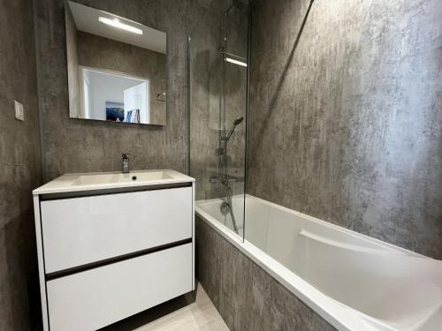 La salle de bains est pourvue d'un lavabo, d'une baignoire et d'un miroir. dans l'établissement Appartement Les Sables-d'Olonne, 2 pièces, 4 personnes - FR-1-197-536, à Les Sables-dʼOlonne