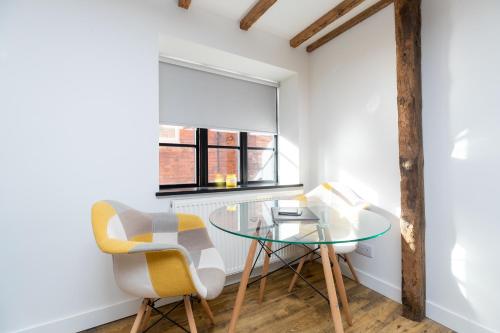 a room with a glass table and two chairs at The Warehouse in Banbury