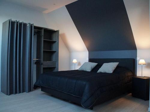 sypialnia z czarnym łóżkiem z 2 poduszkami w obiekcie Studio de charme à la ferme près de Lille, 50m² avec cuisine équipée et parking sécurisé - FR-1-510-173 w mieście Halluin