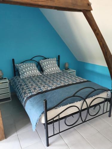 a bed in a room with a blue wall at Gîte du ronthaunay in Saint-Clément