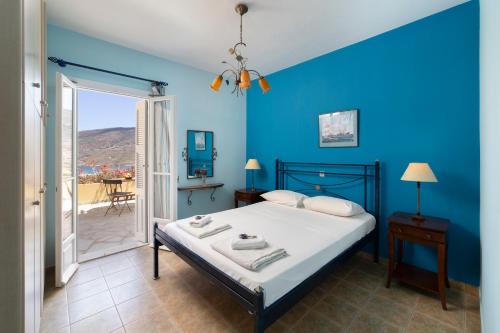 a bedroom with a bed and a blue wall at Spertos Apartments in Órmos