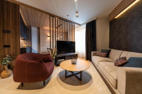 uma sala de estar com um sofá e uma mesa em Aparthotel Woodside by Anaya em Kopaonik