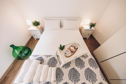 a bedroom with a bed with a tray of food on it at Saturo Apartments in Leporano