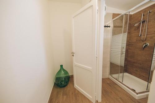 a bathroom with a glass shower and a vase at Saturo Apartments in Leporano