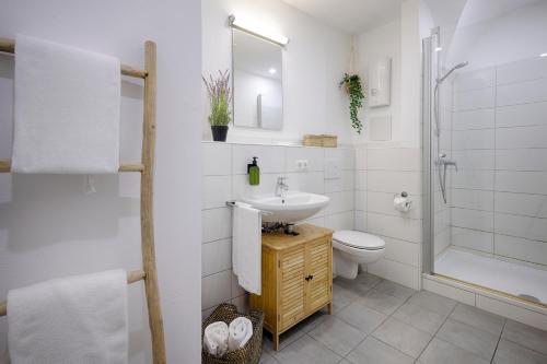 a bathroom with a sink and a toilet and a shower at Fewos zur Alten Brauerei - am Main Ochsenfurt - by homekeepers in Ochsenfurt