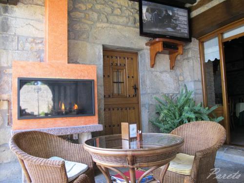 a patio with a fireplace and a table and chairs at Posada La Victoria in Miengo