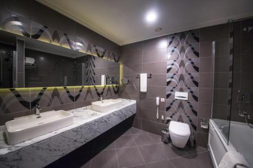 a bathroom with two sinks and a toilet at Hilly Hotel in Edirne