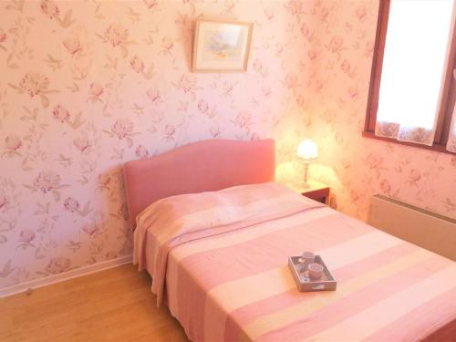 - une petite chambre avec un lit et du papier peint rose dans l'établissement Charmant T2 avec Balcon et Garage - 6 couchages à Saint-Lary-Soulan - FR-1-457-149, à Saint-Lary-Soulan