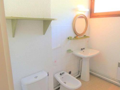 a bathroom with a sink and a toilet and a mirror at Appartement Saint-Lary-Soulan, 2 pièces, 6 personnes - FR-1-457-149 in Saint-Lary-Soulan