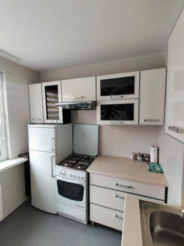 a kitchen with white cabinets and a stove top oven at Apartamenty Częstochowa in Częstochowa