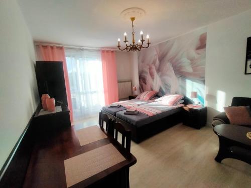 a bedroom with a bed with a painting on the wall at Apartamenty Częstochowa in Częstochowa