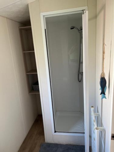 a glass door leading to a closet in a room at Angie's caravan at Seawick in Saint Osyth