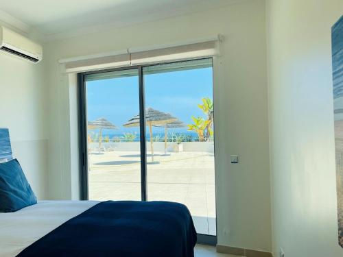 um quarto com uma cama e vista para a praia em On The BEACH Stunning Apartment Albufeira Olhos de Água em Albufeira