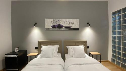 two beds sitting next to each other in a room at Vila Jasmine in Tirana