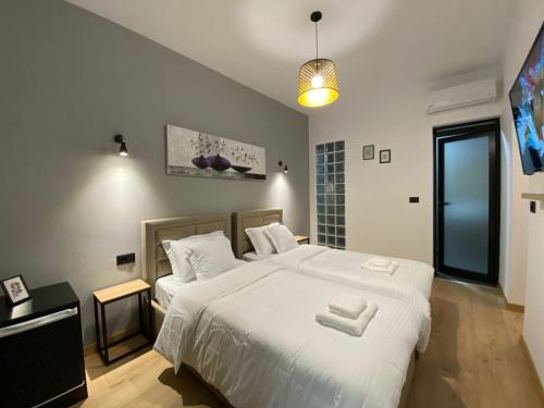 a bedroom with a large white bed with two white towels at Vila Jasmine in Tirana
