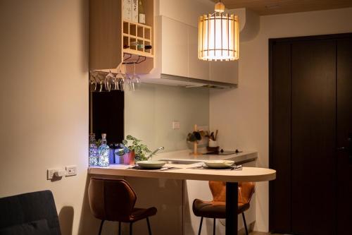 頭城的住宿－宜蘭溫泉海景冉冉拾光，厨房配有桌椅和灯具