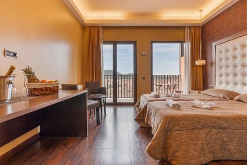 um quarto de hotel com duas camas e uma varanda em Fuente del Miro em Valderrobres