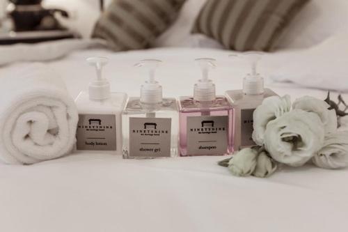 a group of four bottles of soap and towels on a bed at 99 The Heritage Hotel in Chiang Mai
