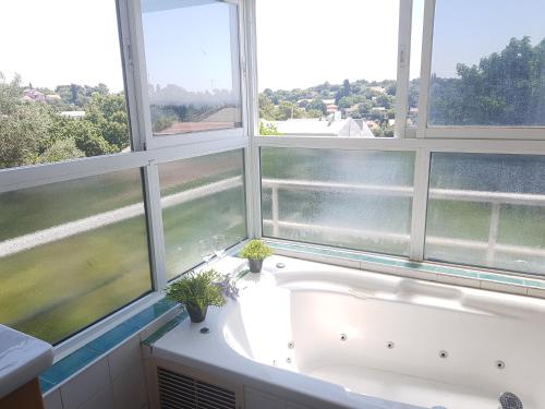 a large bath tub in a room with windows at Galilean villa with jacuzzi in Qiryat ‘Amal