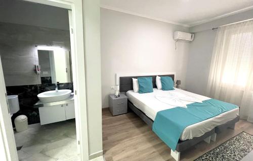 a bedroom with a bed and a bathroom with a sink at Hotel New York in Kamëz