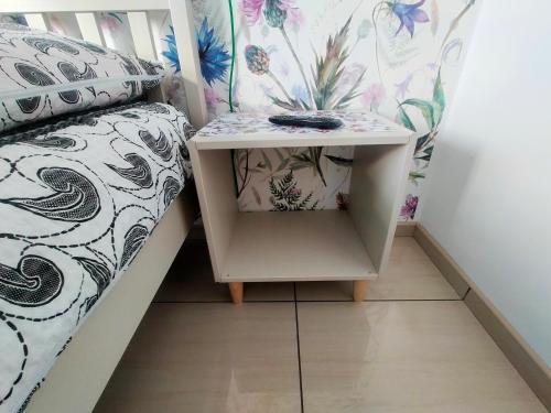 a side table next to a bed in a room at Apartamenty Częstochowa in Częstochowa
