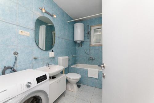 a bathroom with a toilet sink and a washing machine at Apartment Nona - Center, 150 meters from the beach in Supetar