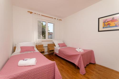 Zimmer mit 2 Betten und einem Fenster in der Unterkunft Apartment Nona - Center, 150 meters from the beach in Supetar
