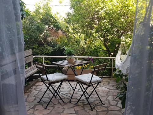 a patio with a table and chairs and a hammock at Galilean villa with jacuzzi in Qiryat ‘Amal